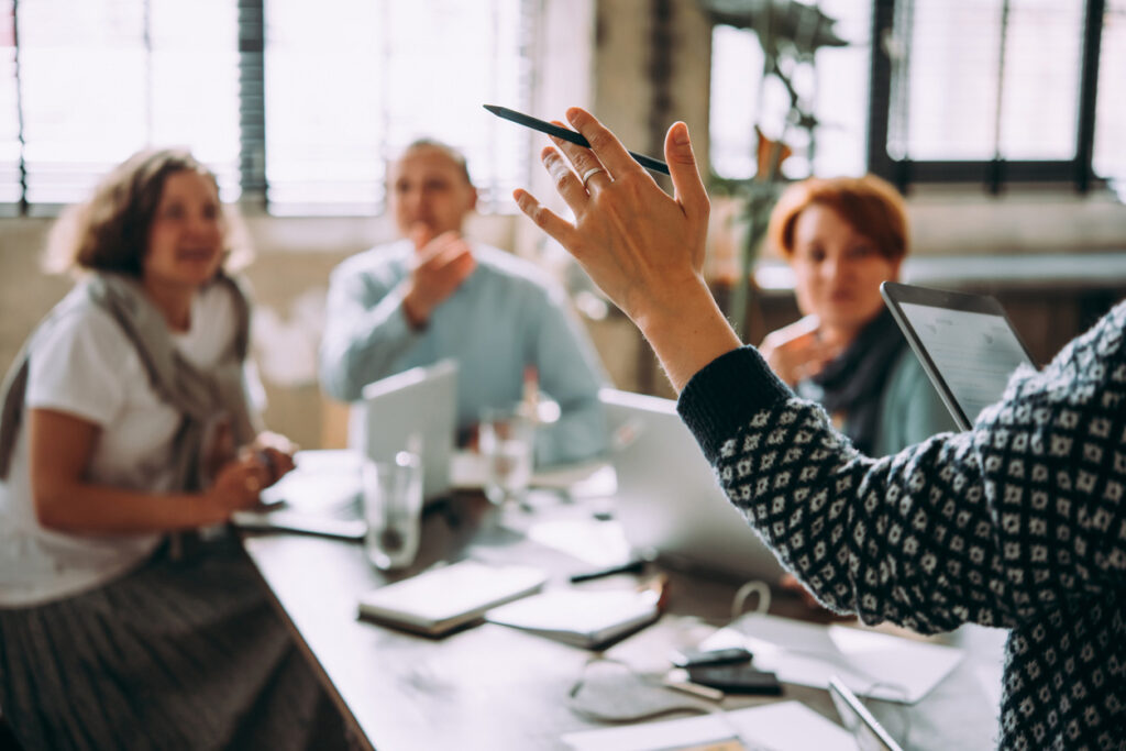 4 Menschen bei der Arbeit am Schreibtisch